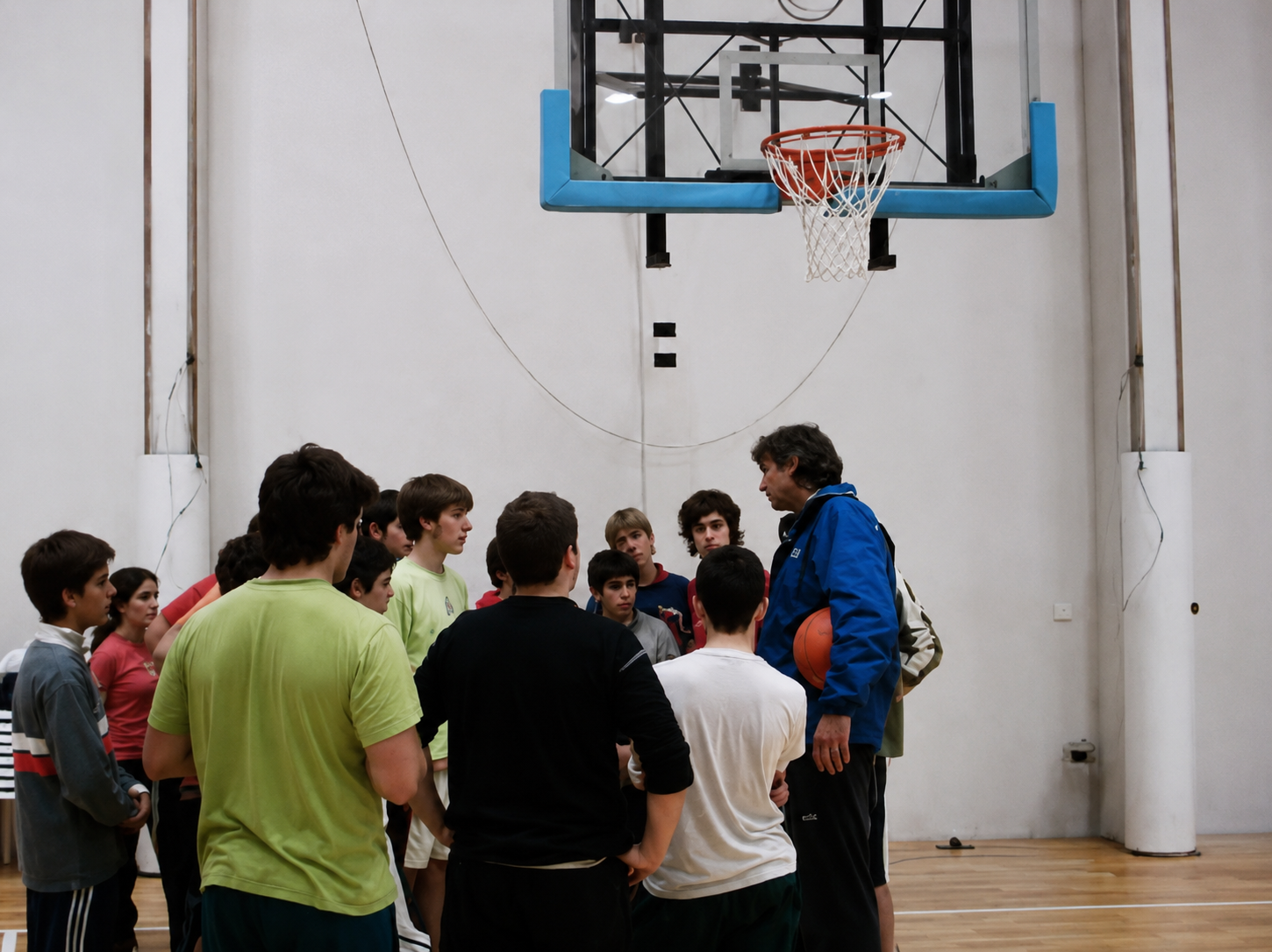 Diego Maggi speaking to players beneath the basket during training