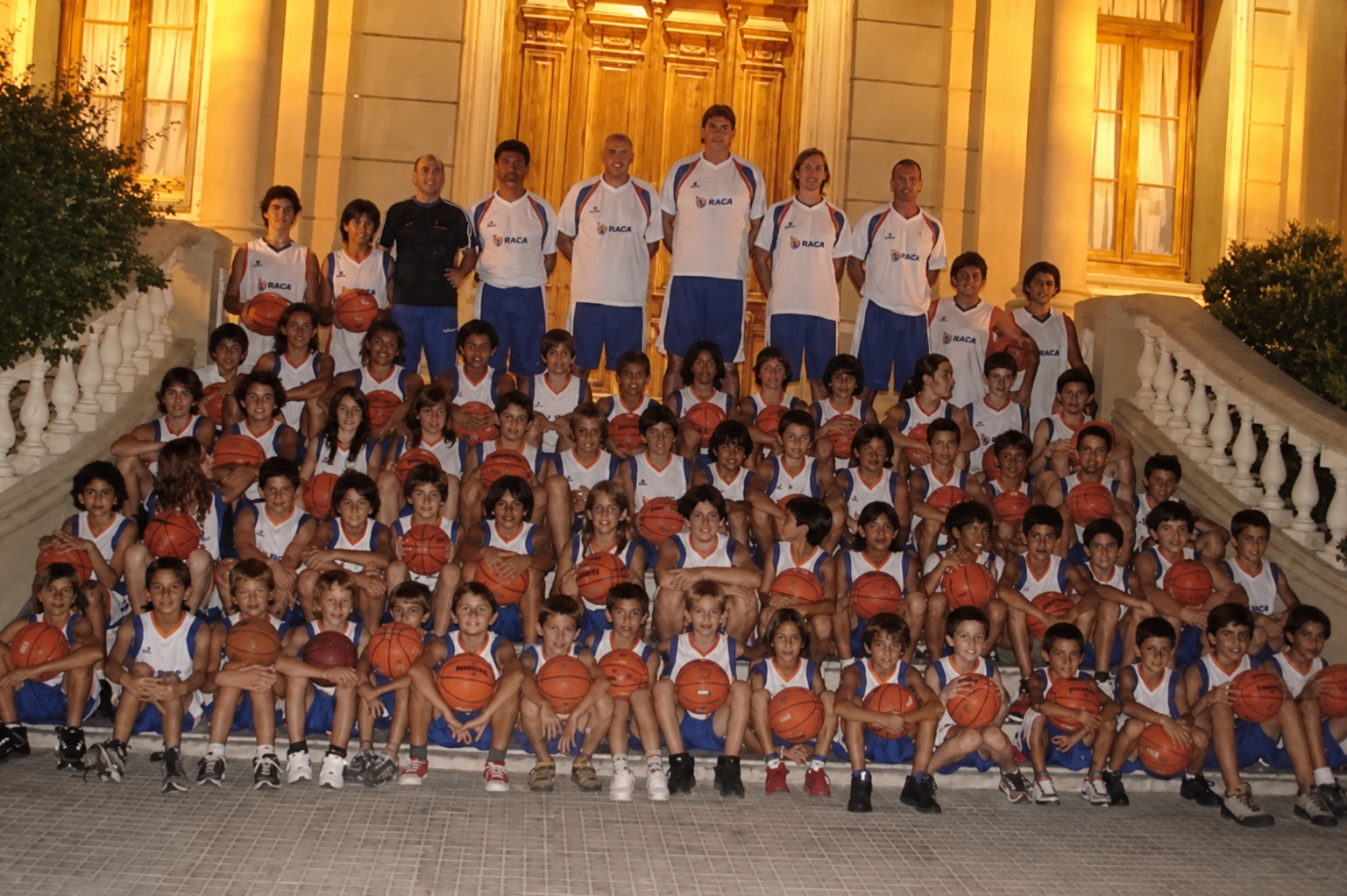 Large youth basketball group photo outdoors at night